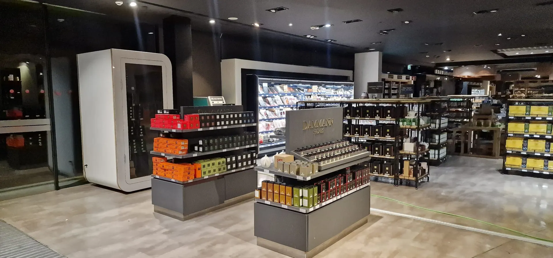 A white single-person Silentbox Solo booth on a retail sales floor, next to product display counters and shelving.